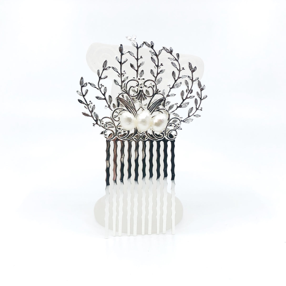 The Vine Hair Comb is a beautiful and versatile piece of jewelry that is perfect for adding a touch of elegance and whimsy to any outfit. The comb is silver plated and features faux pearls, as well as solid wire wrap work that guarantees its reliable quality. The comb has the perfect size for holding the hair in place. The vine design of the comb is associated with elegance and the otherworldly beauty of elves and greek mythology.