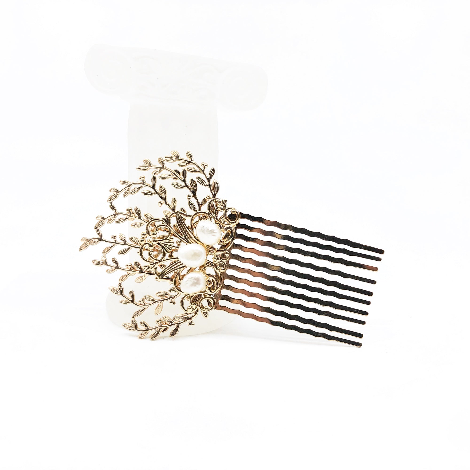 The Vine Hair Comb is a beautiful and versatile piece of jewelry that is perfect for adding a touch of elegance and whimsy to any outfit. The comb is gold plated and features baroque pearls, as well as solid wire wrap work that guarantees its reliable quality. The comb has the perfect size for holding the hair in place. The vine design of the comb is associated with elegance and the otherworldly beauty of elves and greek mythology.