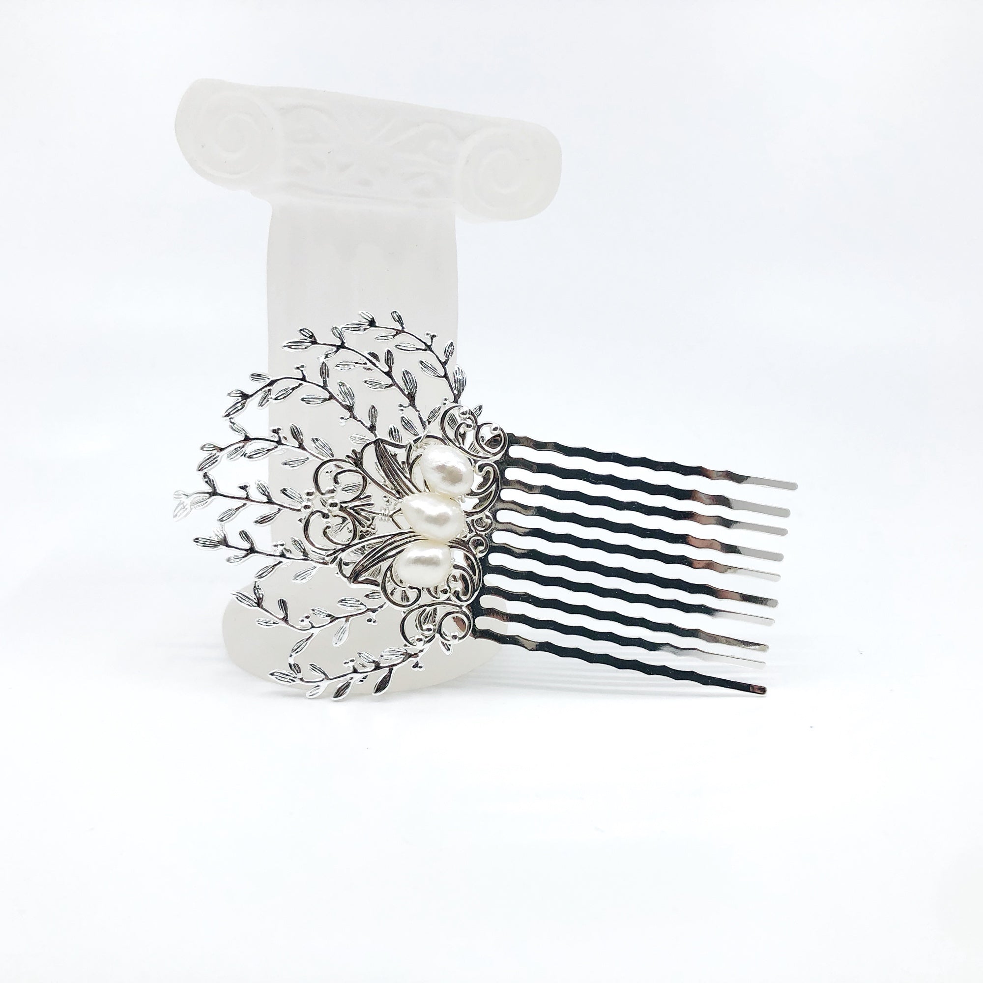 The Vine Hair Comb is a beautiful and versatile piece of jewelry that is perfect for adding a touch of elegance and whimsy to any outfit. The comb is silver plated and features faux pearls, as well as solid wire wrap work that guarantees its reliable quality. The comb has the perfect size for holding the hair in place. The vine design of the comb is associated with elegance and the otherworldly beauty of elves and greek mythology.